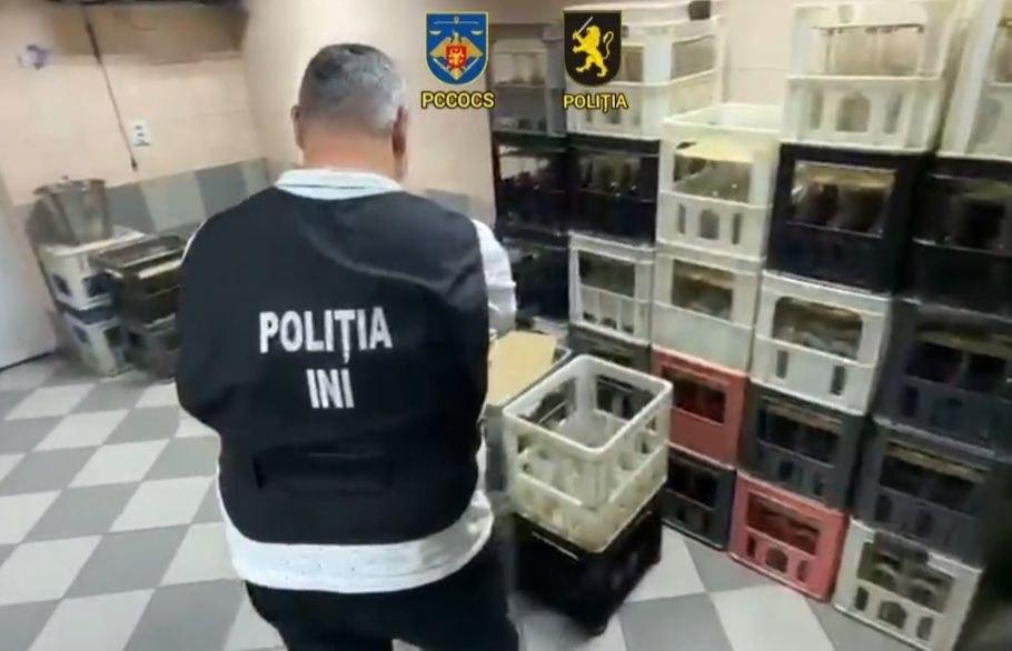 VIDEO | Fabrică ilegală de alcool, destructurată la Chișinău. Sute de sticle de divin și timbre false, ridicate
